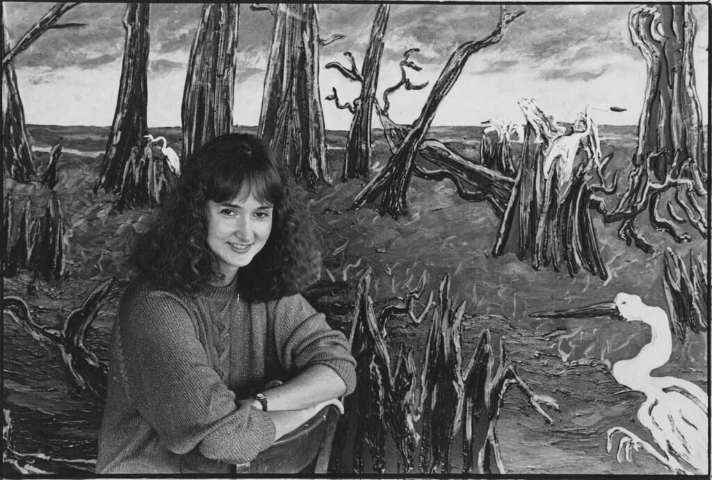 Nina Beall in front of her paintings